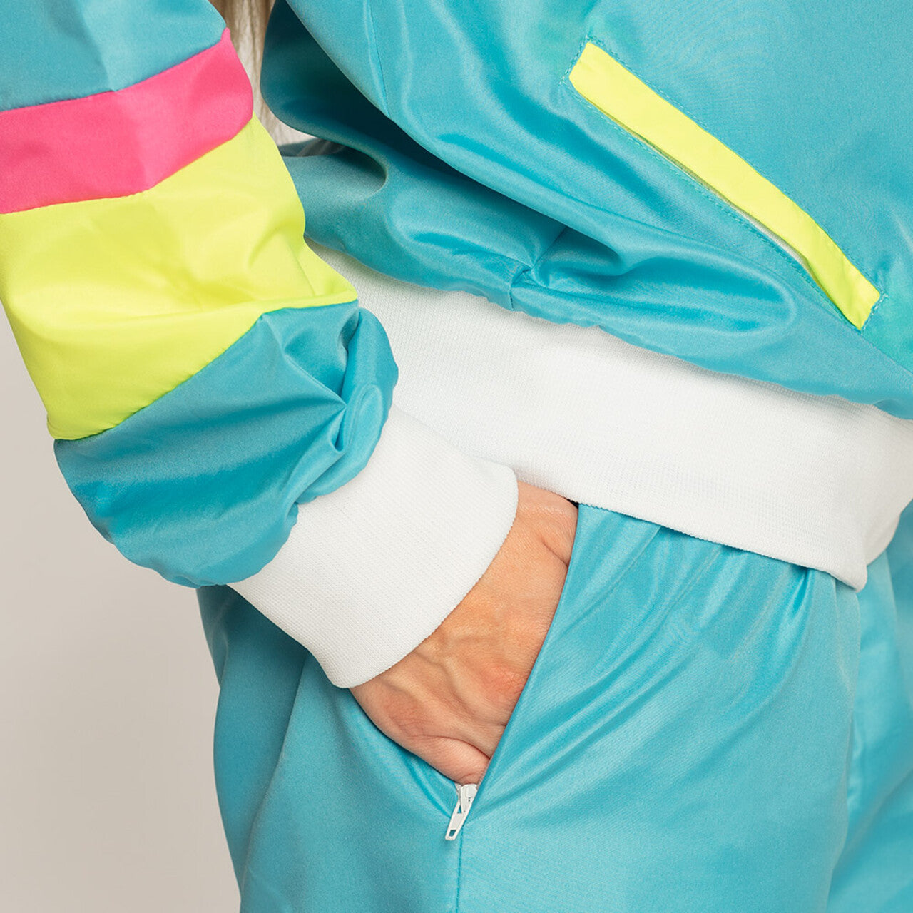 Op deze afbeelding zie je een Kostuums, van het merk Boland. Trainingspak Retro Babe Neonblauw Vrouw Kostuum